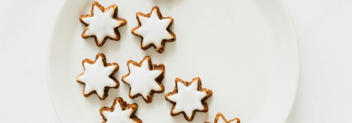 Aesthetic star-shaped iced cookies on a white plate, perfect for festive occasions.