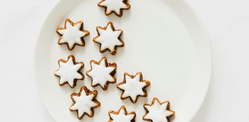 Aesthetic star-shaped iced cookies on a white plate, perfect for festive occasions.